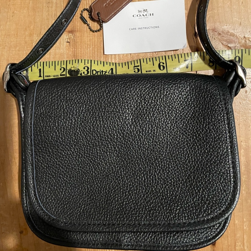 Like new Coach leather black crossbody, flap bag with design at gusset.